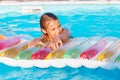 Little girl playing and having fun in swimming pool with air mat Royalty Free Stock Photo