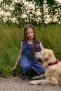 Little girl playing with her big dog outdoors in rural areas in summer Royalty Free Stock Photo