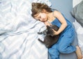 Little girl is playing with her cat on the bed Royalty Free Stock Photo