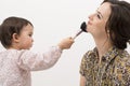 Little girl playing with her mom's makeup isolated