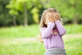 Little girl is playing hide-and-seek hiding face Royalty Free Stock Photo