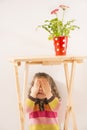 Little girl is playing hide-and-seek hiding face Royalty Free Stock Photo