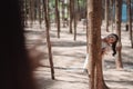 Little girl playing hiding behind tree and waving hand with family Royalty Free Stock Photo