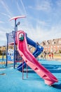 Little girl playing on the high slide at the children playground. Royalty Free Stock Photo