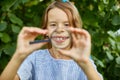 Little girl playing with a magnifying glass in her backyard make faces Royalty Free Stock Photo