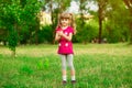Little girl playing on the meadow on sun with windmill in her hands. Child holding wind toy Royalty Free Stock Photo