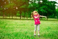 Little girl playing on the meadow on sun with windmill in her hands. Child holding wind toy Royalty Free Stock Photo