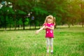 Little girl playing on the meadow on sun with windmill in her hands. Child holding wind toy Royalty Free Stock Photo