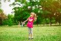 Little girl playing on the meadow on sun with windmill in her hands. Child holding wind toy Royalty Free Stock Photo