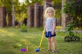 Little girl playing mini golf in spring park. Frustrated child, failure, missed Royalty Free Stock Photo