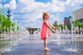 Little girl playing in open street fountain at hot Royalty Free Stock Photo