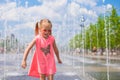 Little girl playing in open street fountain at hot Royalty Free Stock Photo