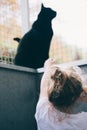 Little girl playing in outdoor pen with her black cat - Pets and Children Concept Royalty Free Stock Photo