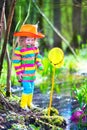 Little girl playing outdoors catching a frog