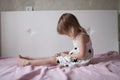 Little girl playing with the phone on the bed, the house, the re