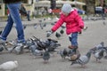 Little girl playing with pigeons