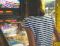 Little girl playing pinball game.