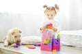 A little girl is playing plastic toys blocks. The dog lies. The Royalty Free Stock Photo