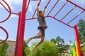 Little girl playing on a playground, hanging walk along the monkey bars Royalty Free Stock Photo