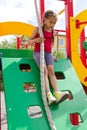 Little girl playing on playground, sliding down the wooden wall Royalty Free Stock Photo