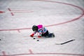 Little girl playing with pucks in hockey rink