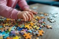 Little girl playing puzzles at home. Child connecting jigsaw puzzle pieces in a living room table. Kid assembling a jigsaw puzzle