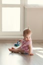 Little girl playing with pyramid on floor Royalty Free Stock Photo