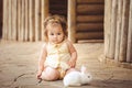 Little girl playing with rabbit in the village. Outdoor. Summer portrait.