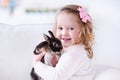 Little girl playing with a real pet rabbit Royalty Free Stock Photo