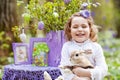 Little girl  playing with real rabbit in the garden. Laughing child at Easter egg hunt with  pet bunny. Spring outdoor fun for Royalty Free Stock Photo