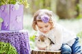 Little girl  playing with real rabbit in the garden. Smiling child at Easter egg hunt with  pet bunny. Spring outdoor fun for kids Royalty Free Stock Photo