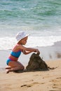 Little girl playing with sand on the beach