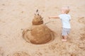 Little girl playing with sand snowman on ocean beach Royalty Free Stock Photo