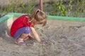 Little girl playing in sandbox on a sunny summer day Royalty Free Stock Photo