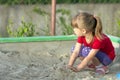 Little girl playing in sandbox on a sunny summer day Royalty Free Stock Photo