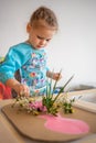 Little girl playing with sensory game, making herbarium. Sensory development and experiences, themed activities with