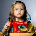 Little girl is playing with sewing machine Royalty Free Stock Photo