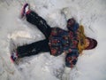 Little girl playing snow angel