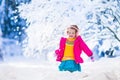 Little girl playing snow ball fight in winter park Royalty Free Stock Photo
