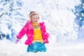 Little girl playing snow ball fight in winter park Royalty Free Stock Photo