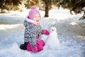 Little girl playing with a snowman Royalty Free Stock Photo