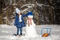 Little girl playing with a snowman Royalty Free Stock Photo