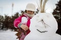 Little girl playing with snowman Royalty Free Stock Photo