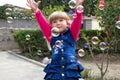 Little beautiful girl walks with a soft toy in their hands. On open air.Little girl playing with soap bubbles in the garden Royalty Free Stock Photo