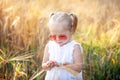 Little girl playing in sunny summer field. Baby in white dress and sunglasses