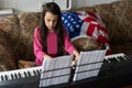 little girl playing synthesizer piano with usa flag at home Royalty Free Stock Photo