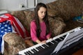 little girl playing synthesizer piano with usa flag at home Royalty Free Stock Photo