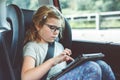 Little girl is playing tablet inside car. Family going on vacation. Preschool child having fun. Royalty Free Stock Photo