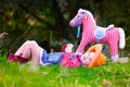 Little girl playing with toy horse in cowboy costume