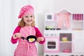 Little girl playing with toy kitchen Royalty Free Stock Photo